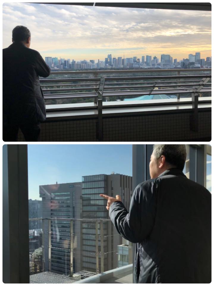 タワーマンションから景色を眺める男性